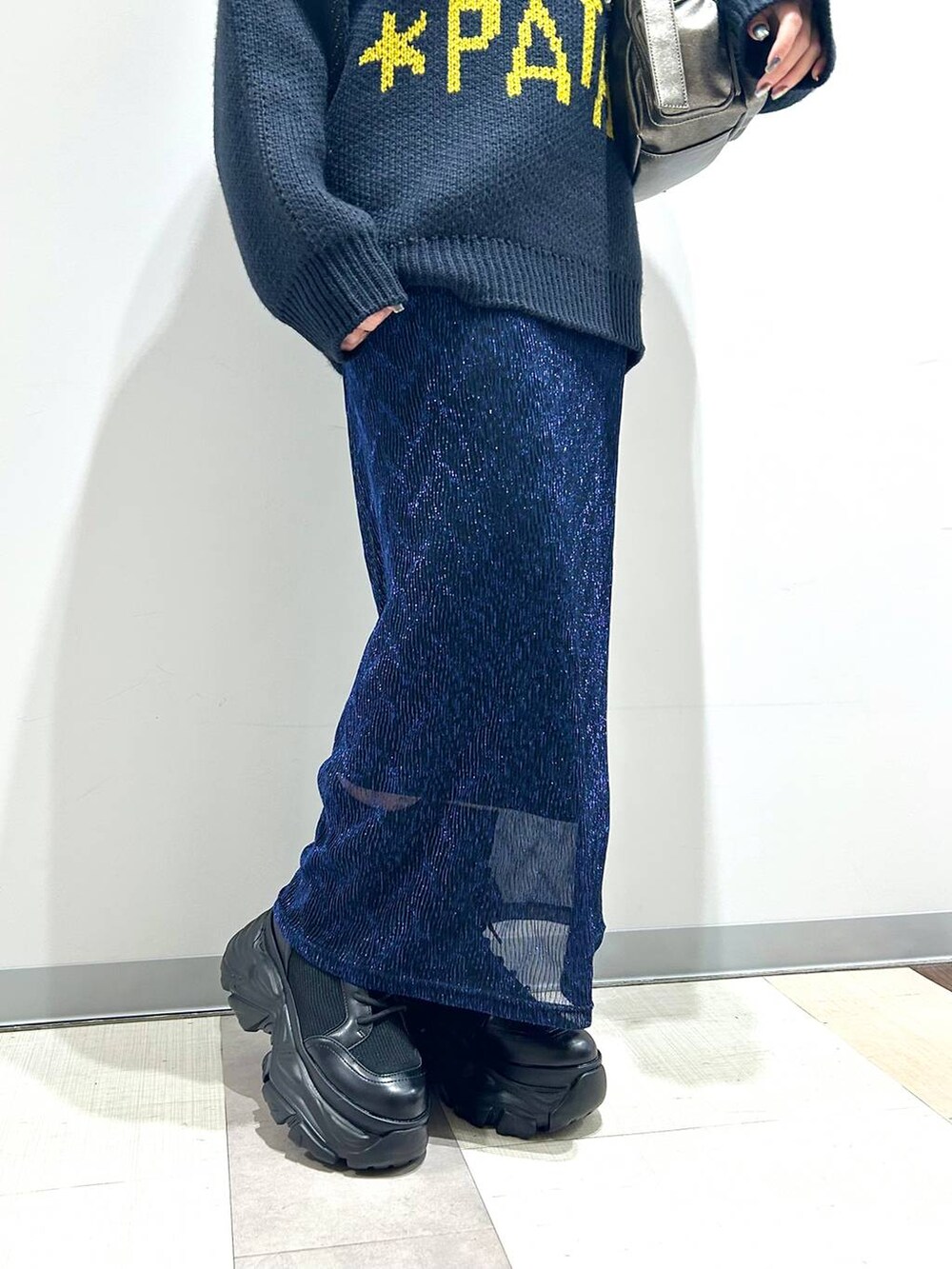 ブラック系のブーツ、その他のショルダーバッグ、ブルー系のニット/セーターを着用したレディースの秋コーディネートの2枚目の写真