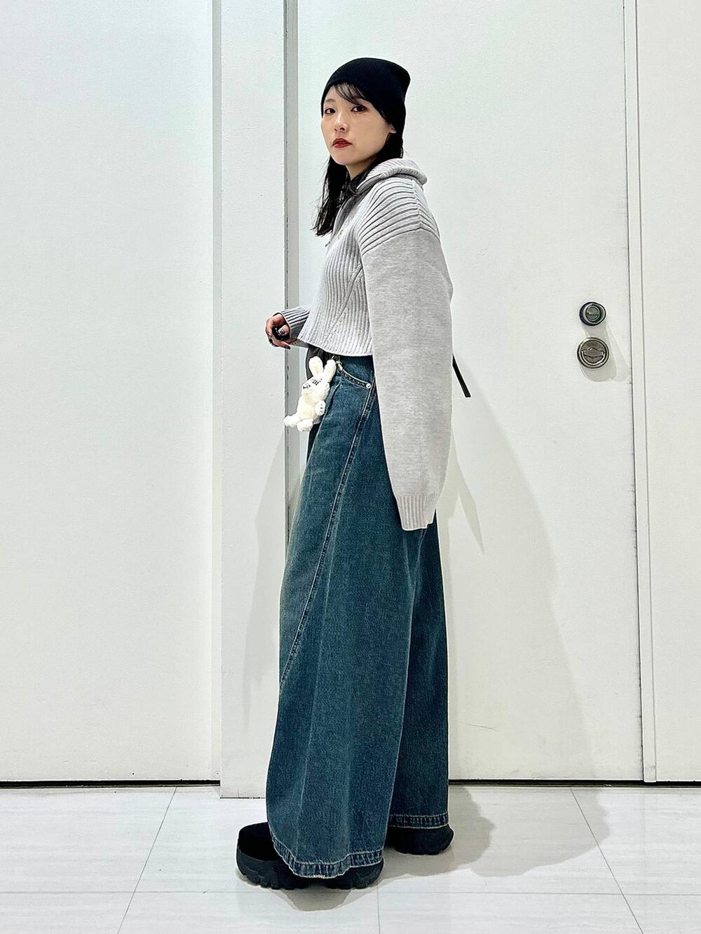 ブルー系のデニムパンツ、グレー系のショルダーバッグ、グレー系のニット/セーターを着用したレディースの秋コーディネートの6枚目の写真