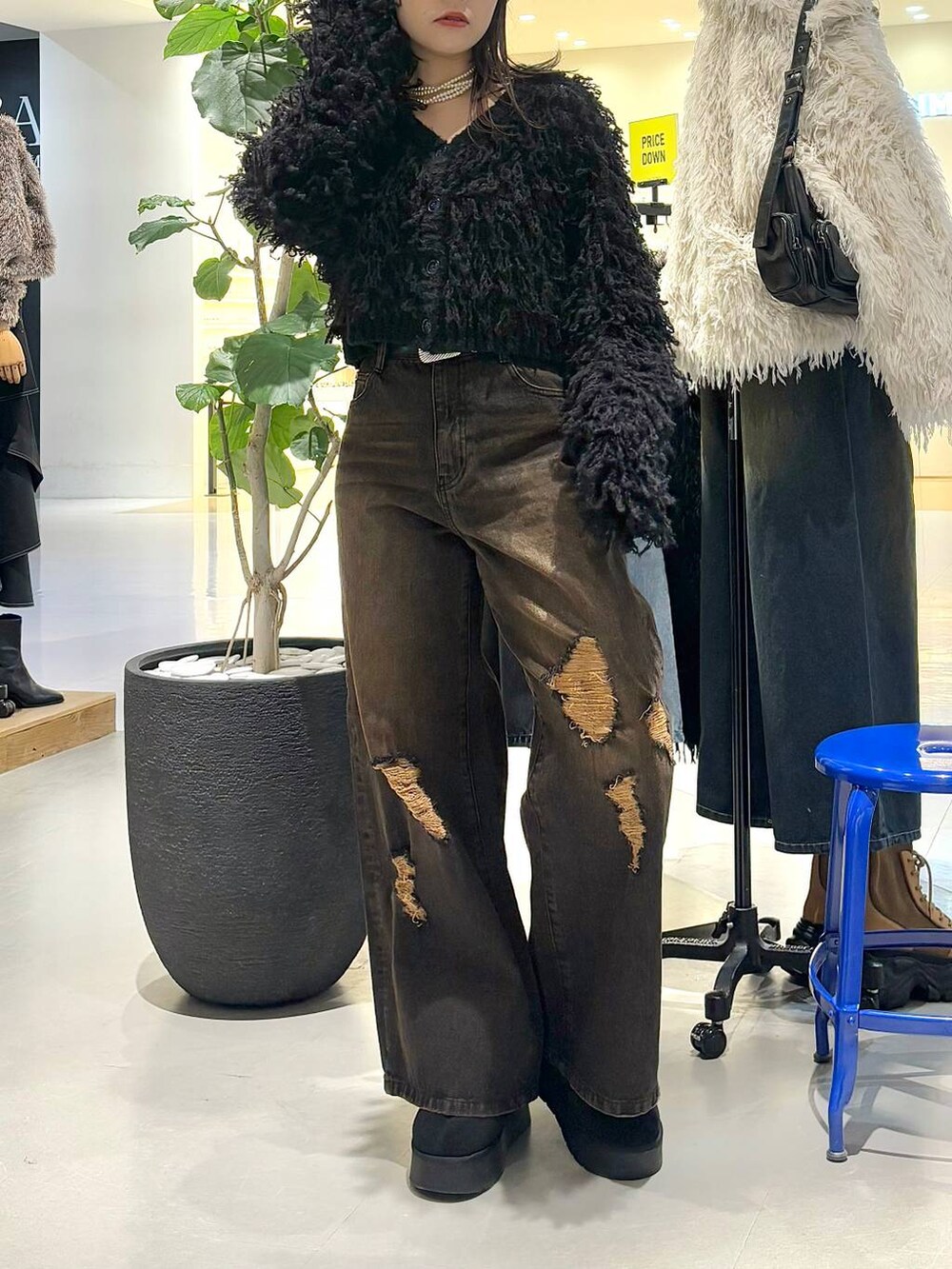 ブラック系のカーディガン/ボレロ、ブラック系のデニムパンツ、ブラック系のベルトを着用したレディースの冬コーディネートの3枚目の写真