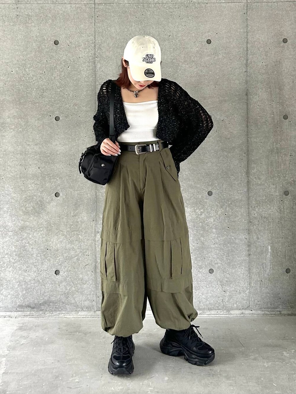 ブラック系のショルダーバッグ、ブラック系のスニーカー、グリーン系のその他パンツを着用したレディースの春コーディネートの3枚目の写真