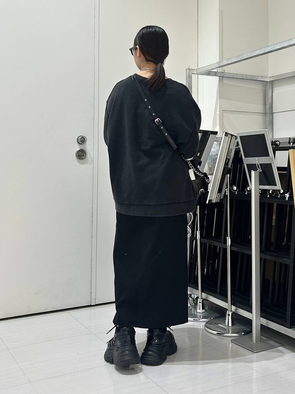 ブラック系のショルダーバッグ、グレー系のスウェット、ブラック系のスカートを着用したレディースの秋コーディネートの5枚目の写真