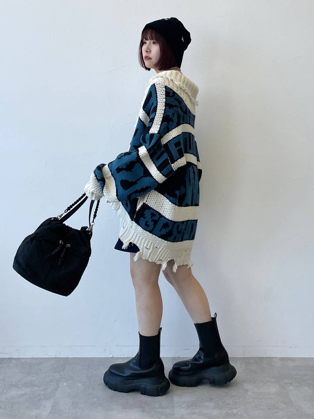 ブラック系のキャミソール、ブラック系のブーツ、ブルー系のスカートを着用したレディースの秋コーディネートの5枚目の写真