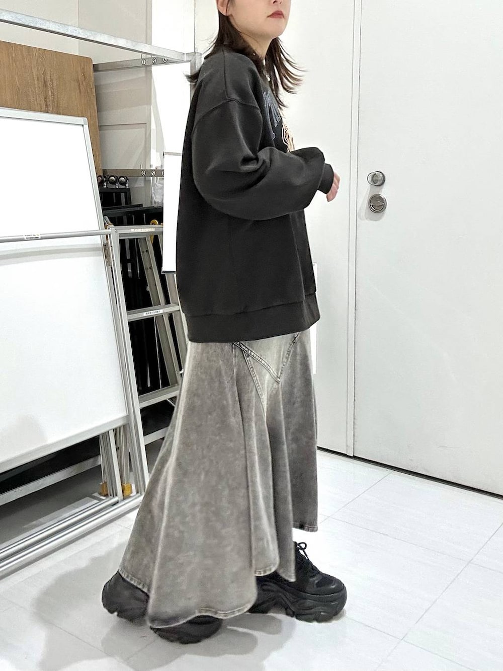 ブラック系のブーツ、グレー系のスウェット、ブラウン系のボストンバッグを着用したレディースの冬コーディネートの5枚目の写真