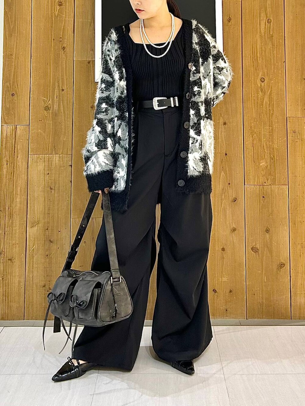 ブラック系のタンクトップ、ブラック系のパンプス、ブラック系のショルダーバッグを着用したレディースの秋コーディネートの3枚目の写真