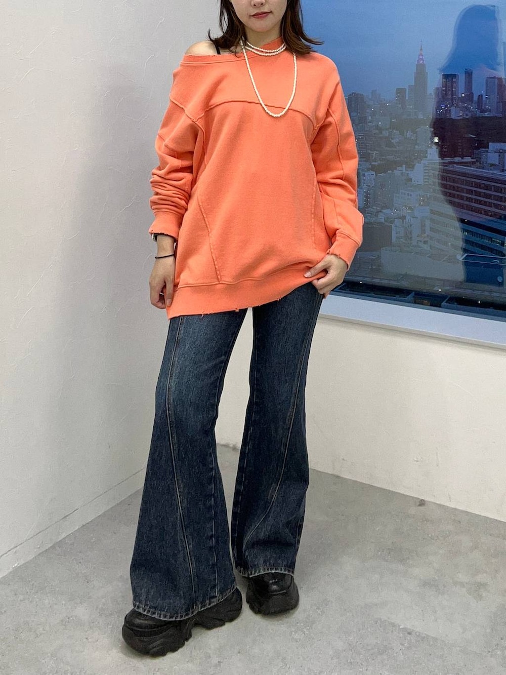 ブルー系のデニムパンツ、ピンク系のスウェットを着用したレディースの秋コーディネートの3枚目の写真