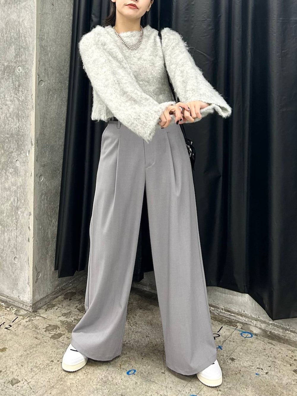 ホワイト系のスニーカー、グレー系のニット/セーター、ブラック系のベルトを着用したレディースの秋コーディネートの5枚目の写真