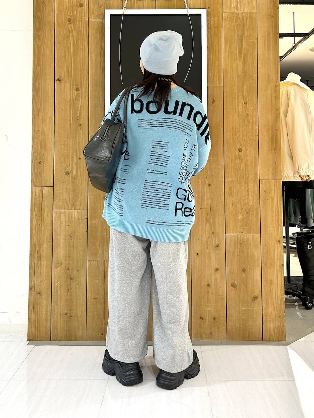 ブラック系のスニーカー、グレー系のボストンバッグ、ブルー系のニット/セーターを着用したレディースの冬コーディネートの5枚目の写真