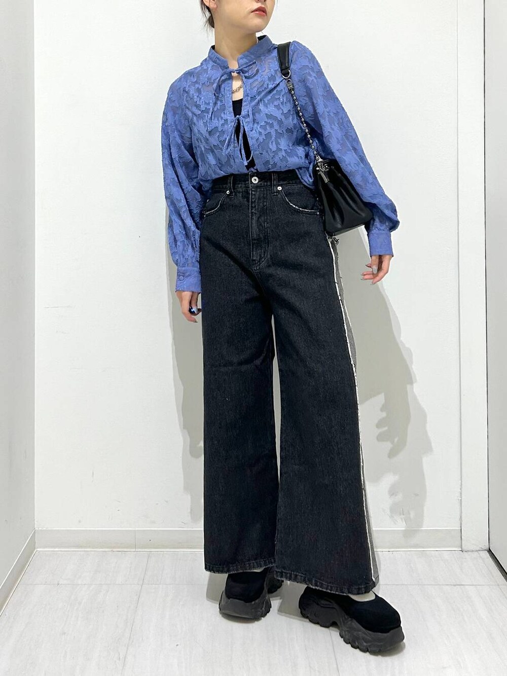 ブラック系のショルダーバッグ、ブラック系のデニムパンツ、ブルー系のシャツ/ブラウスを着用したレディースの春コーディネートの3枚目の写真