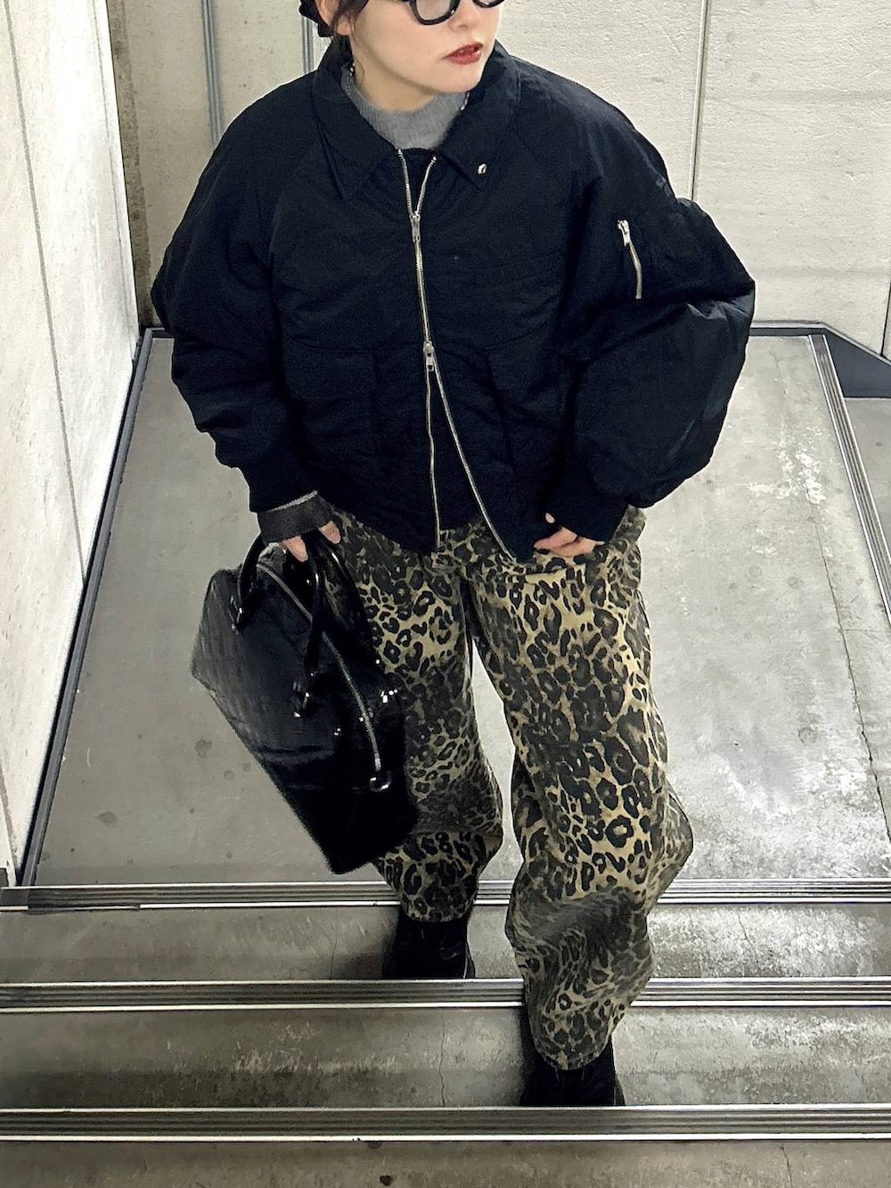 ブラック系のスニーカー、ブラック系のブルゾン、ブラック系のニット/セーターを着用したレディースの冬コーディネートの3枚目の写真