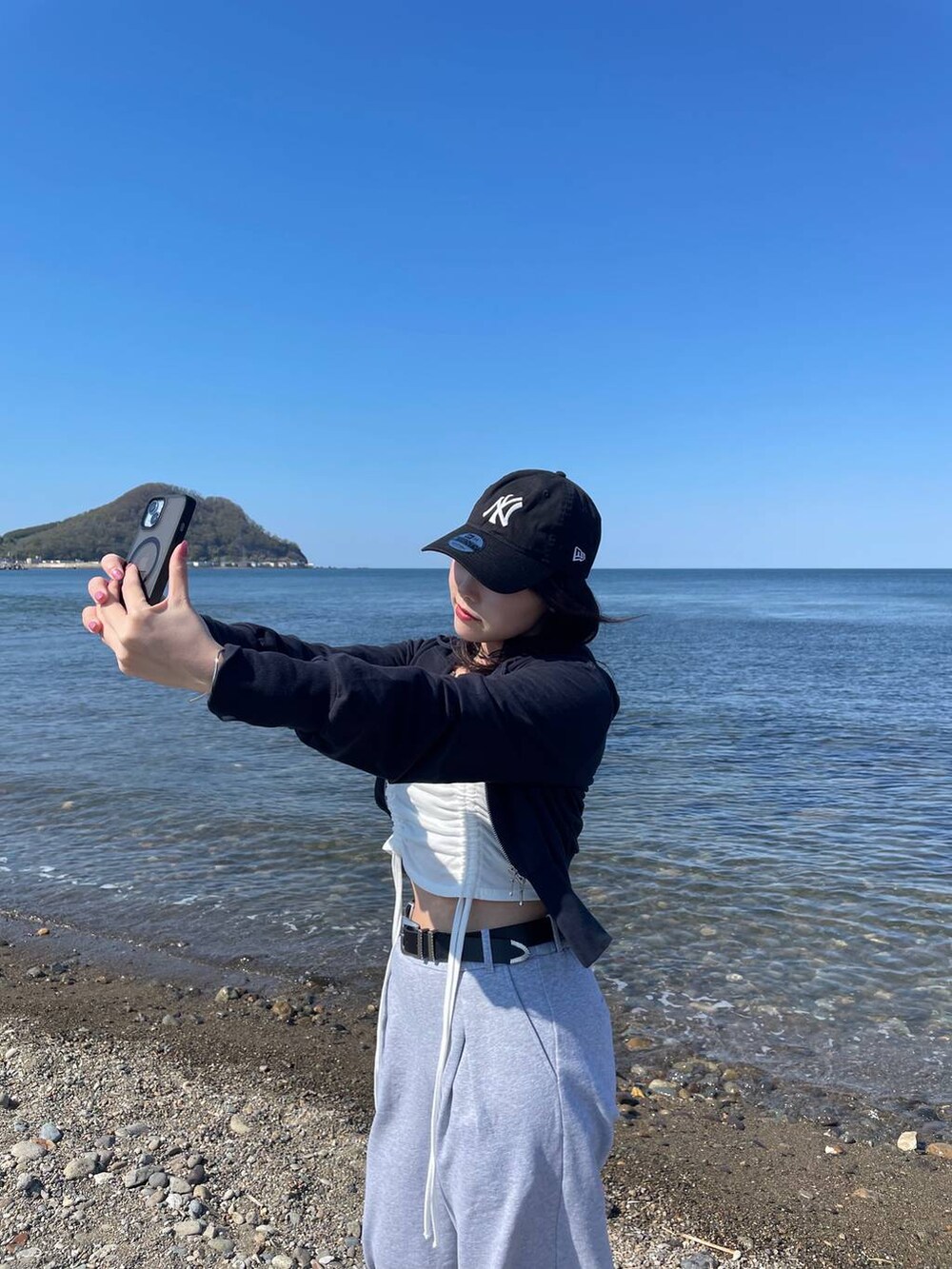 ブラック系のスニーカー、ブルー系のパーカー、グレー系のスウェットパンツを着用したレディースの春コーディネートの4枚目の写真