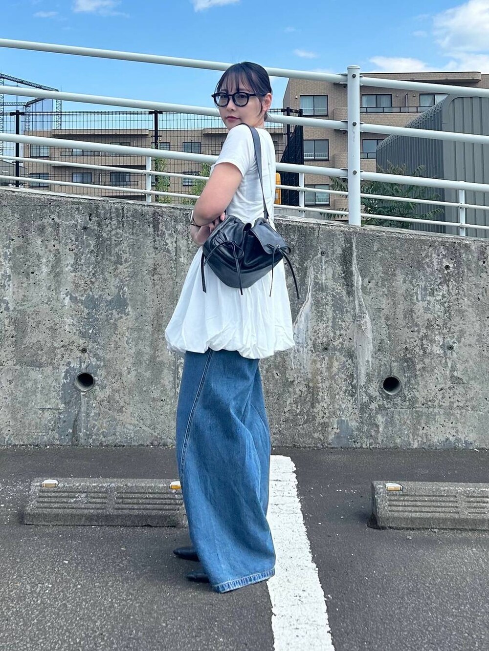 ブルー系のデニムパンツ、ホワイト系のTシャツ/カットソー、ホワイト系のキャミソールを着用したレディースの夏コーディネートの3枚目の写真