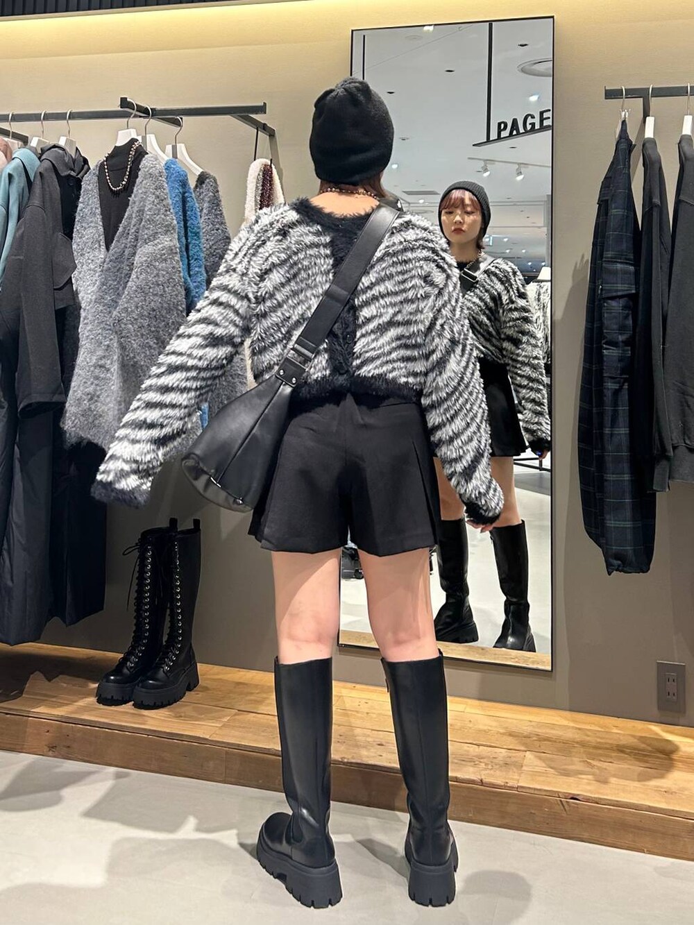 ブラック系のブーツ、ブラック系のショルダーバッグ、その他のカーディガン/ボレロを着用したレディースの秋コーディネートの3枚目の写真