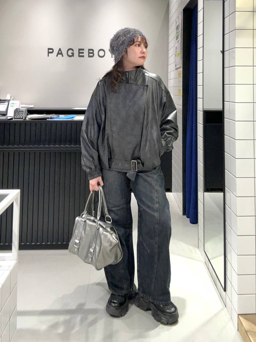 ブルー系のデニムパンツ、ブラック系のスニーカー、ブラック系のライダースジャケットを着用したレディースの秋コーディネートの3枚目の写真