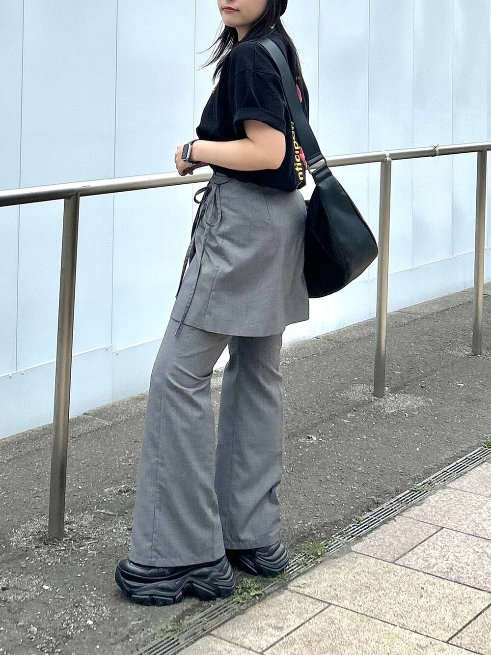ブラック系のショルダーバッグ、グレー系のスカート、グレー系のスラックスを着用したレディースの春コーディネートの5枚目の写真
