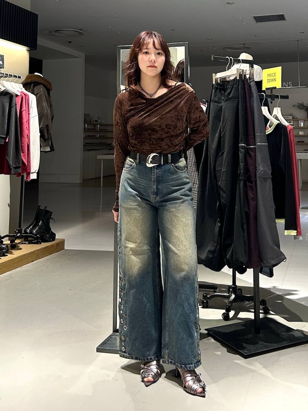 ブラック系のブルゾン、ブルー系のデニムパンツ、ブラウン系のTシャツ/カットソーを着用したレディースの秋コーディネートの3枚目の写真