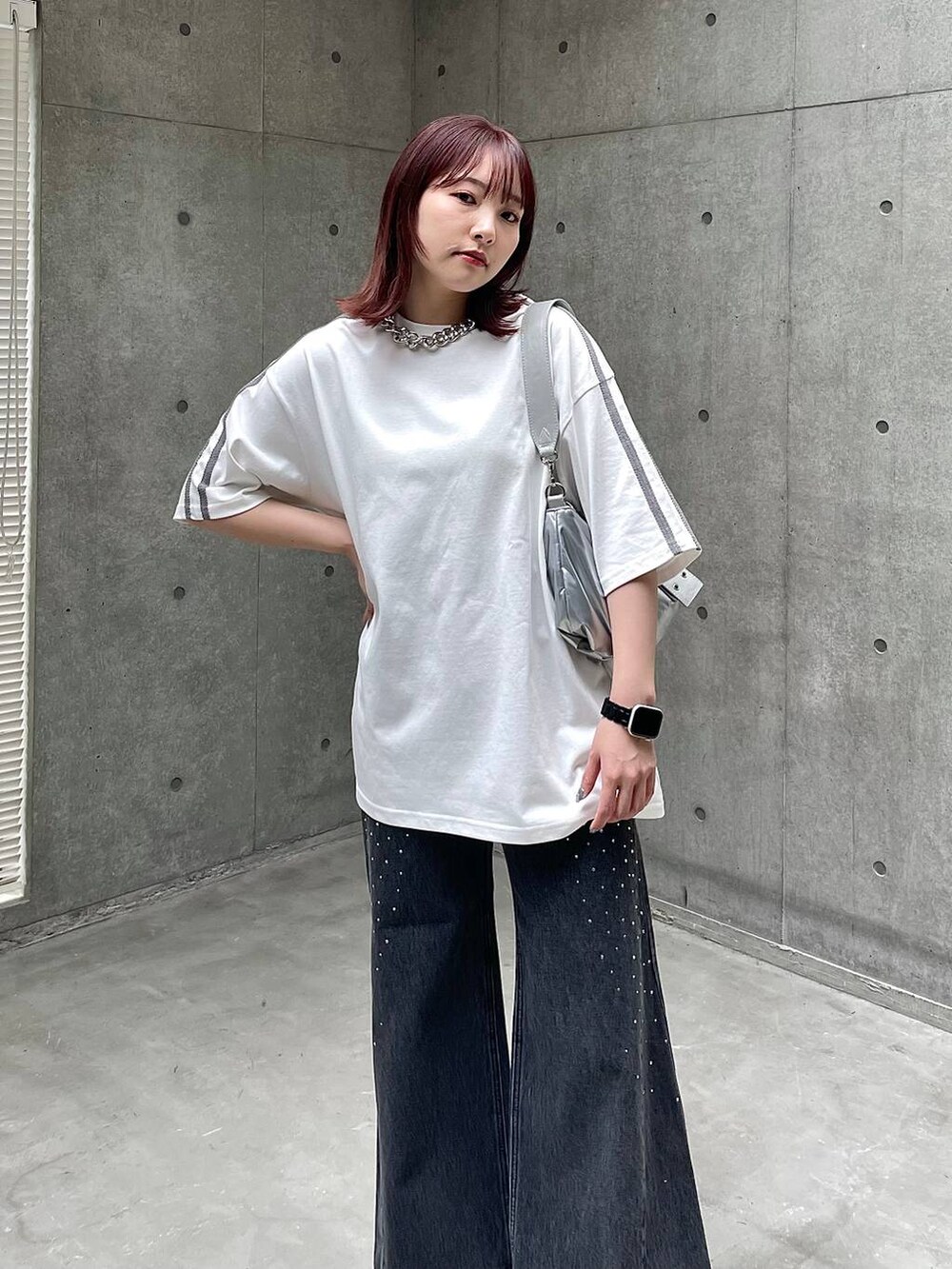 ブラック系のスニーカー、ホワイト系のTシャツ/カットソー、ブラック系のデニムパンツを着用したレディースの春コーディネートの4枚目の写真