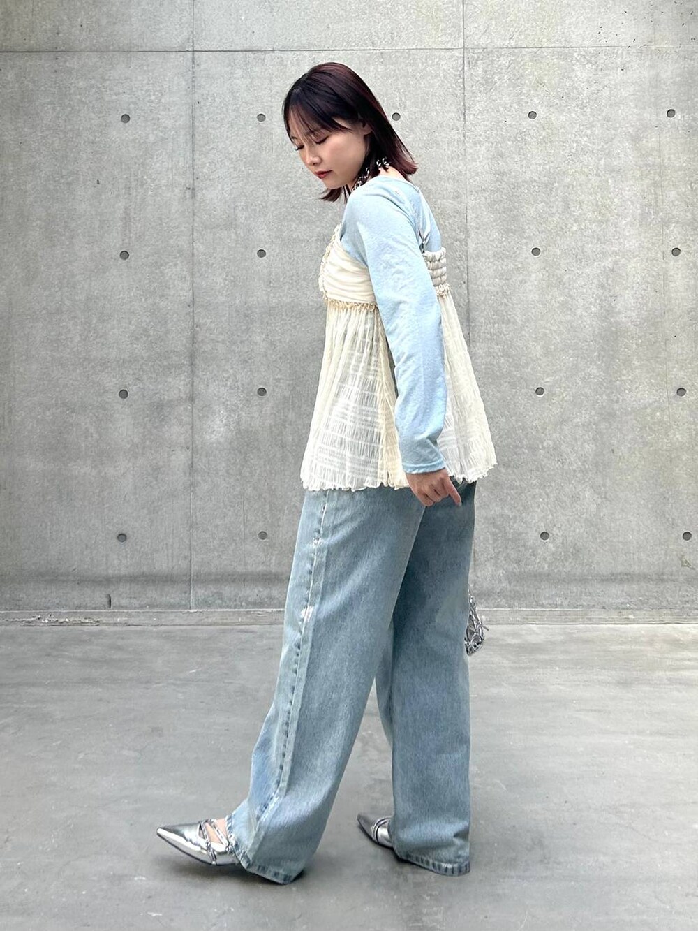 シルバー系のショルダーバッグ、ブルー系のデニムパンツ、ホワイト系のキャミソールを着用したレディースの春コーディネートの6枚目の写真