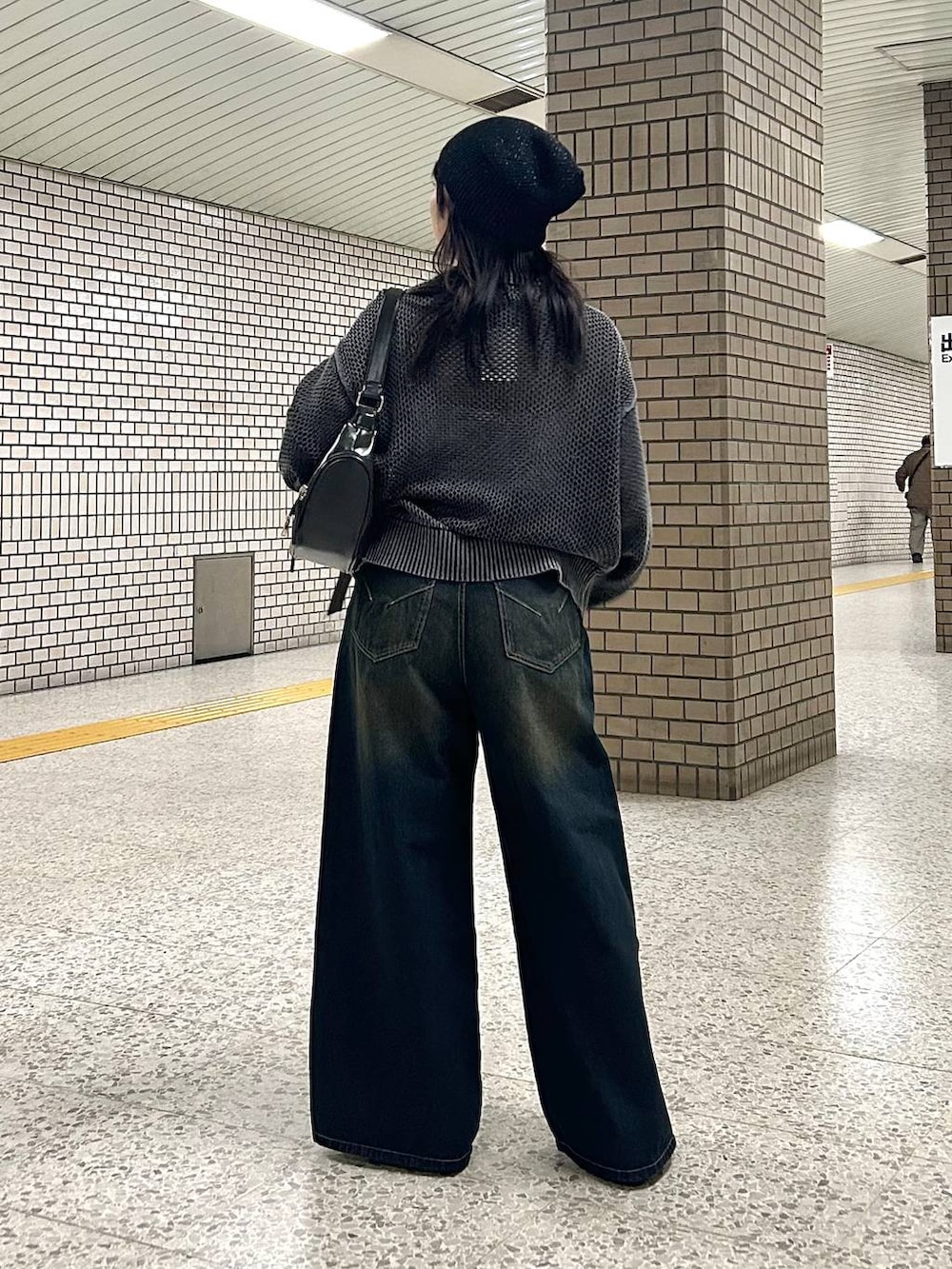 ブルー系のデニムパンツ、ブラック系のパンプス、ブラック系のショルダーバッグを着用したレディースの春コーディネートの5枚目の写真