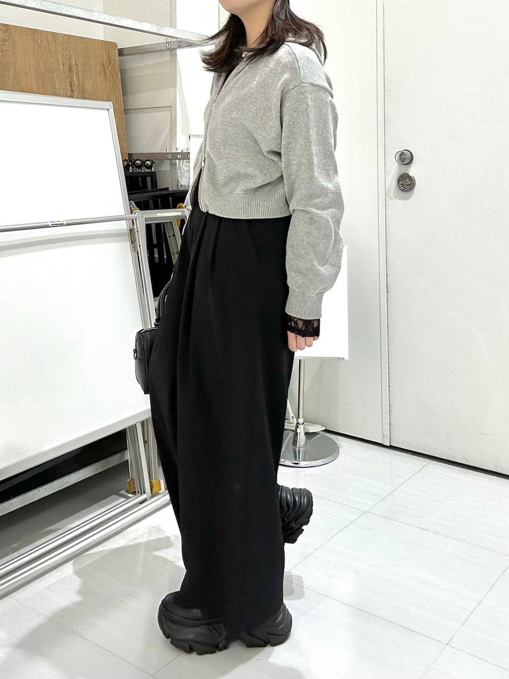 ブラック系のスニーカー、ブラック系のTシャツ/カットソー、ブラック系のボストンバッグを着用したレディースの冬コーディネートの4枚目の写真