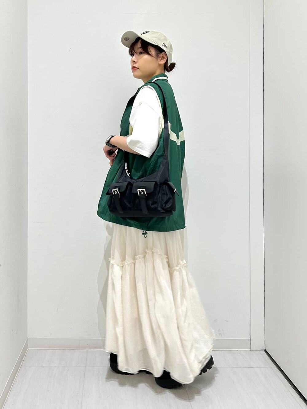 グリーン系のベスト、ホワイト系のスカート、ホワイト系のTシャツ/カットソーを着用したレディースの春コーディネートの5枚目の写真