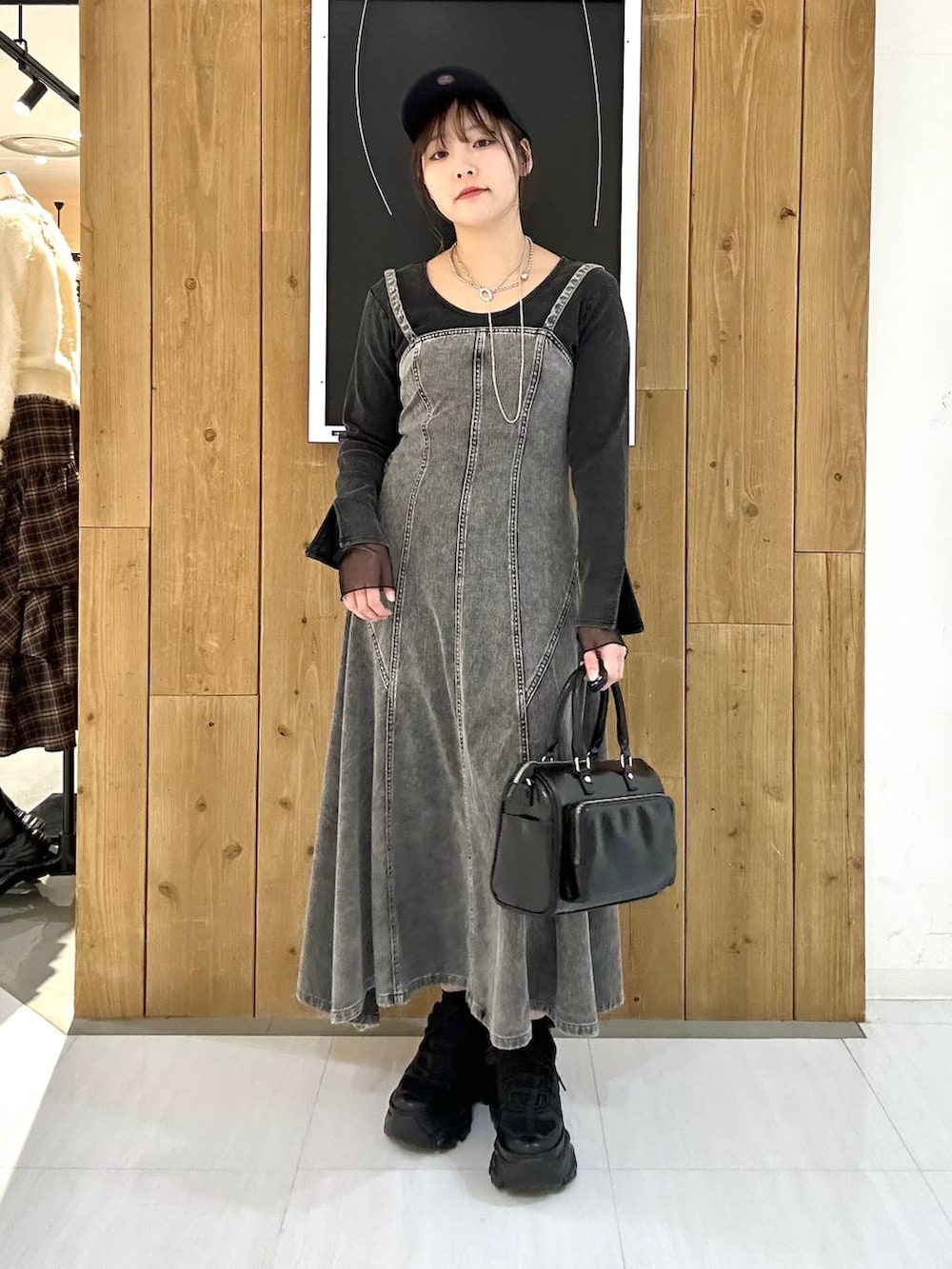 ブラック系のスニーカー、ブラック系のショルダーバッグ、グレー系のTシャツ/カットソーを着用したレディースの冬コーディネートの2枚目の写真