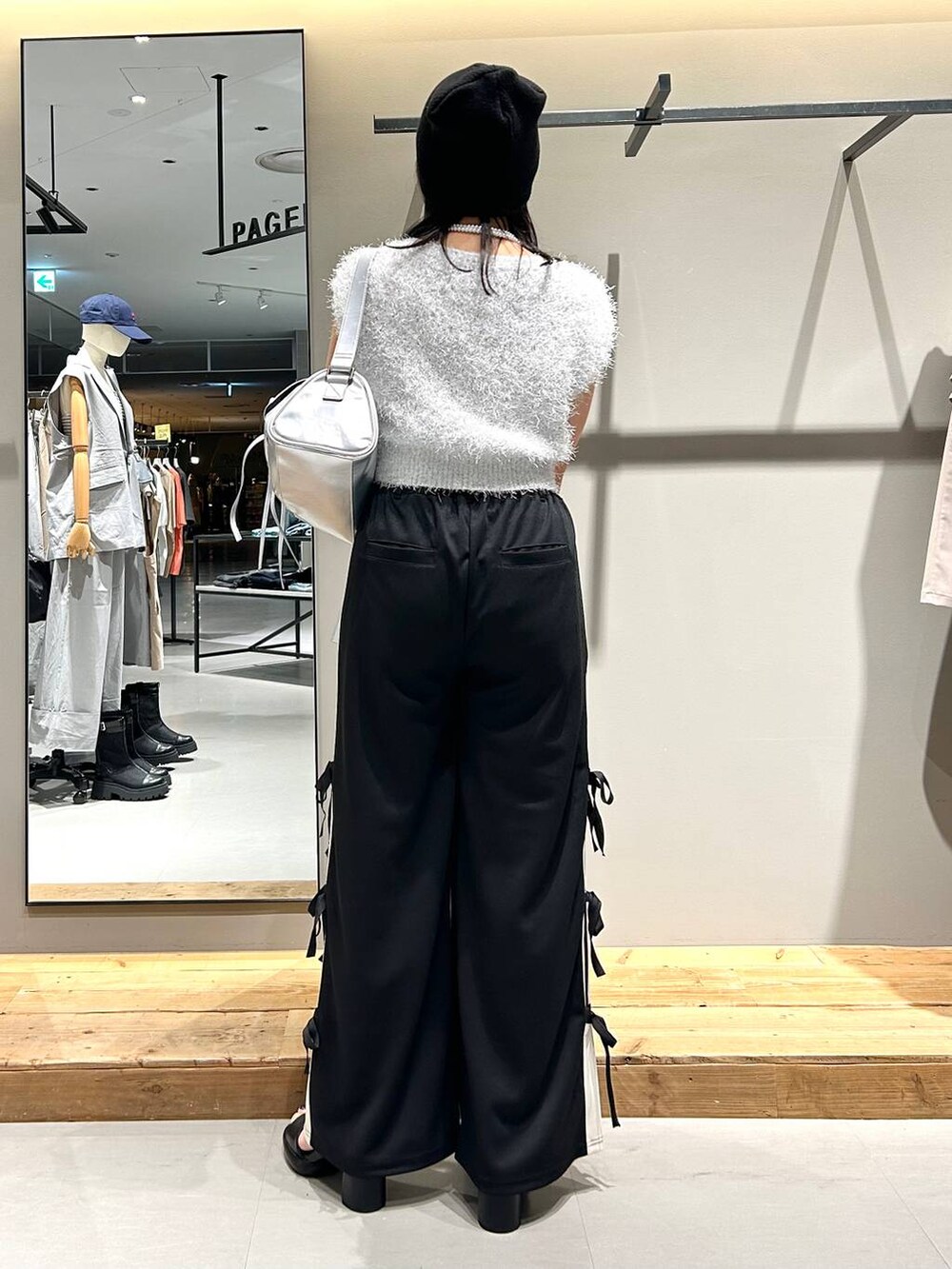 ブラック系のサンダル、ホワイト系のベスト、ブラック系のキャミソールを着用したレディースの夏コーディネートの5枚目の写真