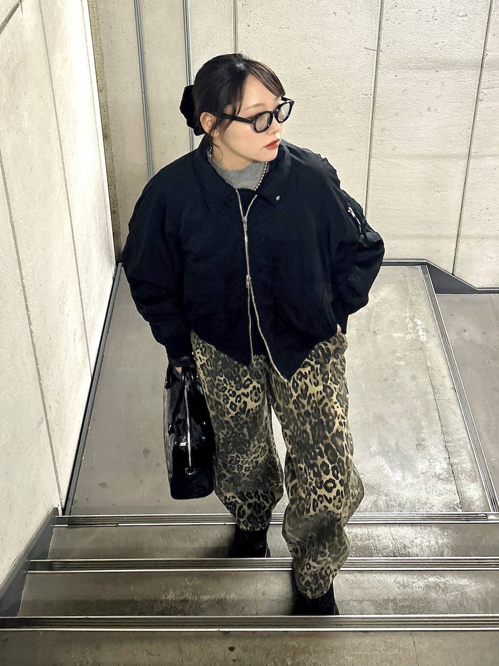 ブラック系のスニーカー、ブラック系のブルゾン、ブラック系のニット/セーターを着用したレディースの冬コーディネートの2枚目の写真