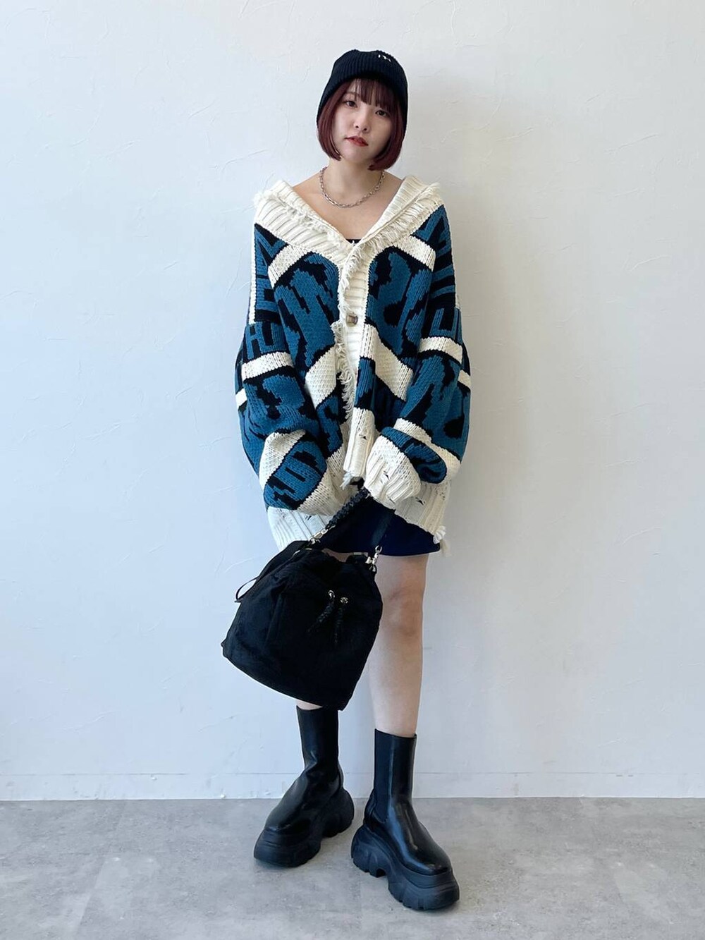 ブラック系のキャミソール、ブラック系のブーツ、ブルー系のスカートを着用したレディースの秋コーディネートの2枚目の写真