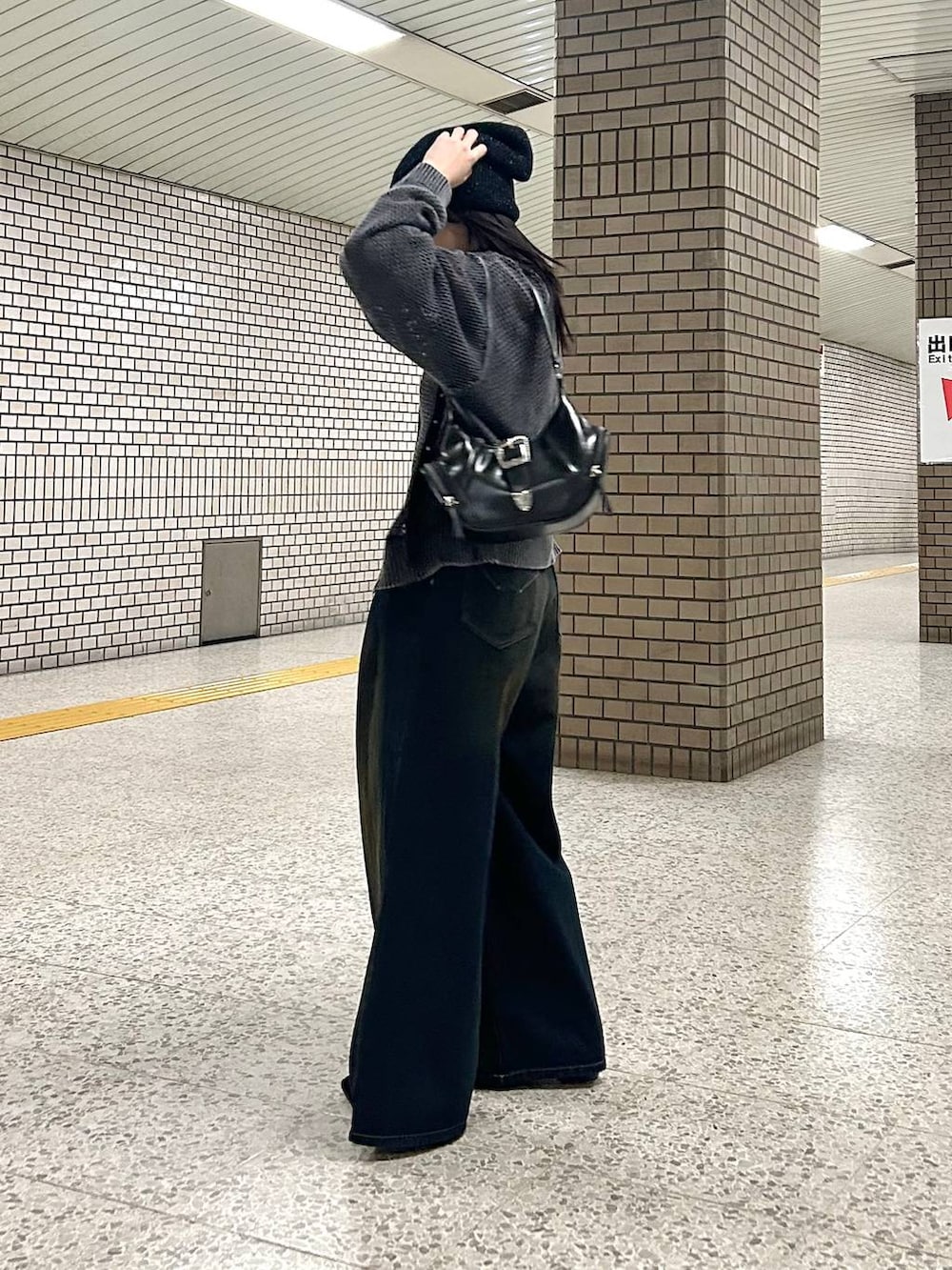 ブルー系のデニムパンツ、ブラック系のパンプス、ブラック系のショルダーバッグを着用したレディースの春コーディネートの4枚目の写真