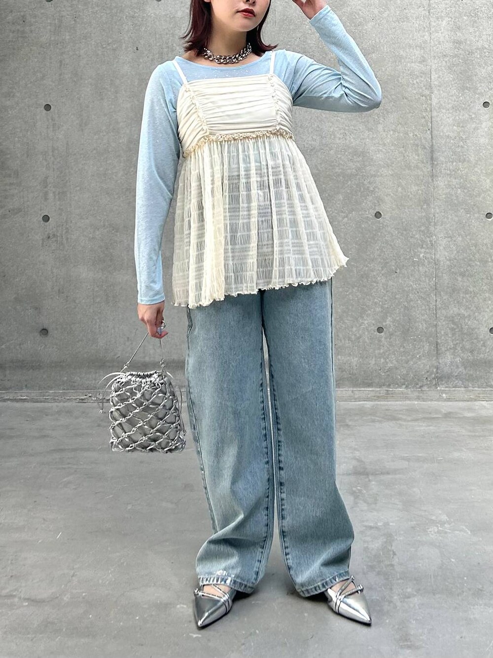 シルバー系のショルダーバッグ、ブルー系のデニムパンツ、ホワイト系のキャミソールを着用したレディースの春コーディネートの3枚目の写真