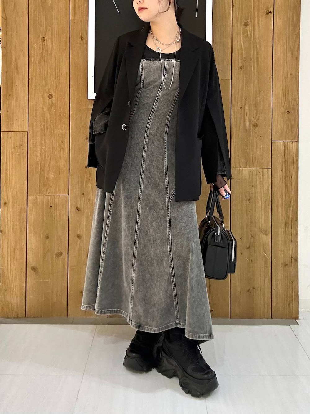 ブラック系のスニーカー、ブラック系のテーラードジャケット、ブラック系のショルダーバッグを着用したレディースの冬コーディネートの3枚目の写真