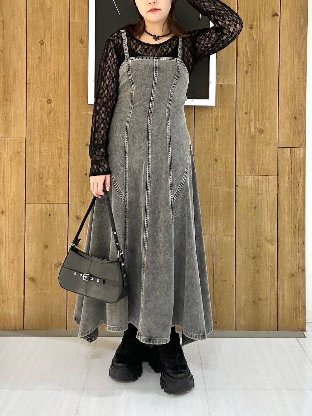 ブラック系のスニーカー、ブラック系のTシャツ/カットソー、ブラック系のハンドバッグを着用したレディースの冬コーディネートの3枚目の写真