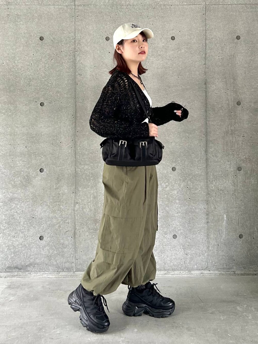 ブラック系のショルダーバッグ、ブラック系のスニーカー、グリーン系のその他パンツを着用したレディースの春コーディネートの4枚目の写真