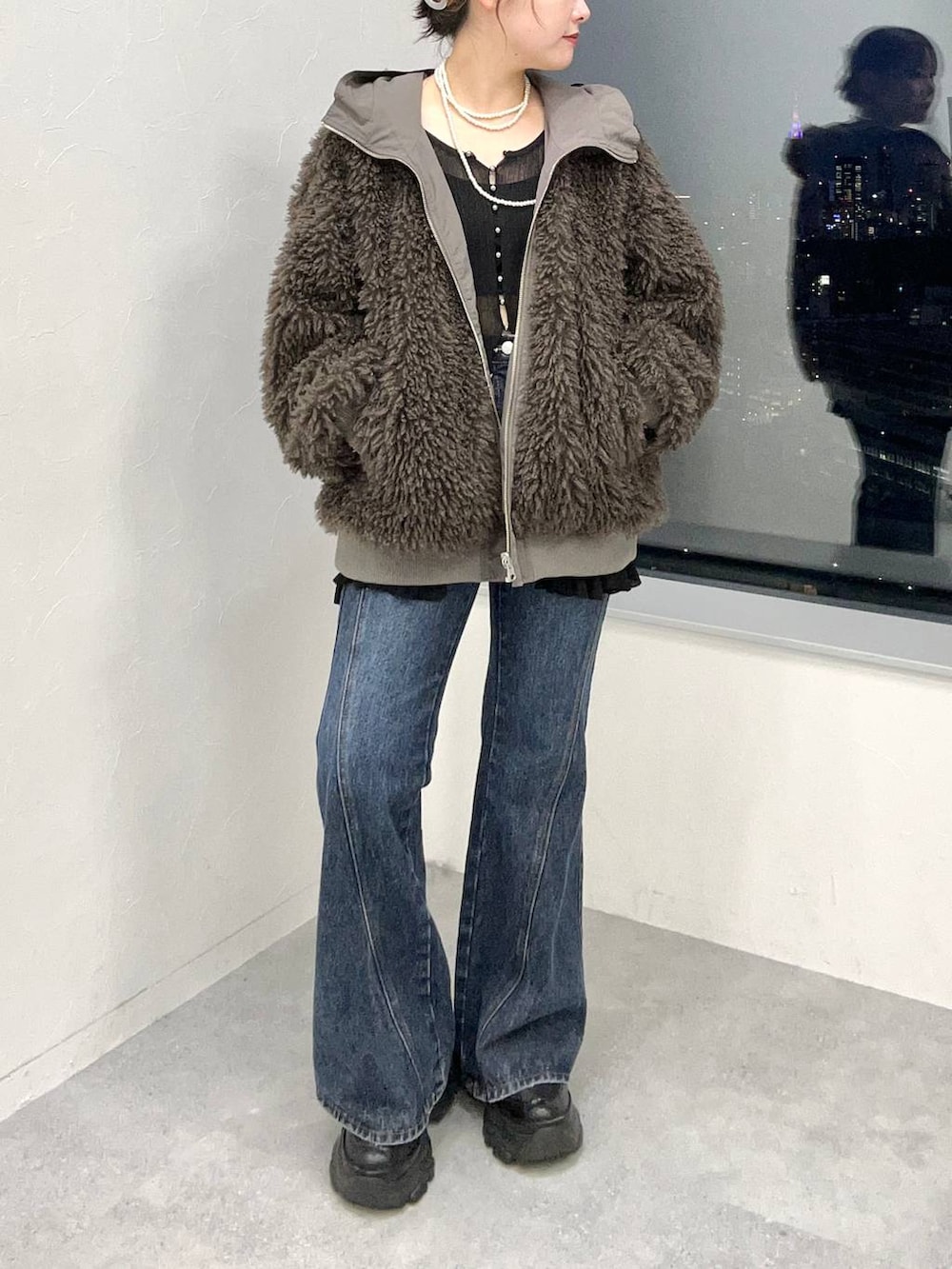 ブルー系のデニムパンツ、ブラウン系のブルゾンを着用したレディースの秋コーディネートの3枚目の写真