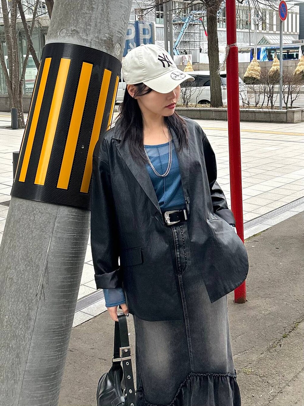 ブラック系のスニーカー、ブラック系のテーラードジャケット、ブラック系のショルダーバッグを着用したレディースの春コーディネートの5枚目の写真