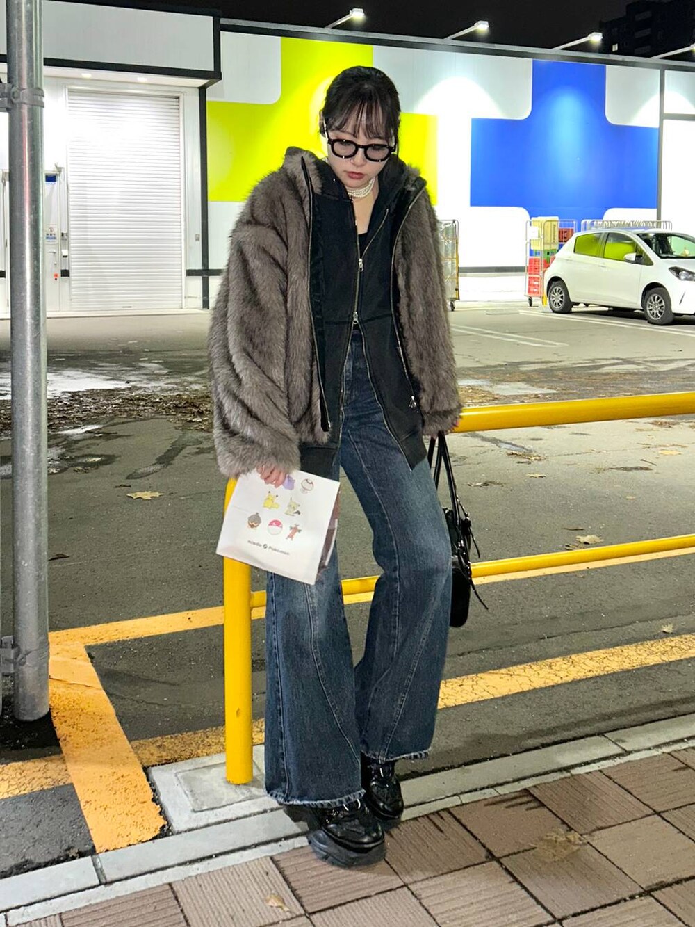 ブルー系のデニムパンツ、ブラック系のパーカー、ブラウン系のブルゾンを着用したレディースの秋コーディネートの2枚目の写真