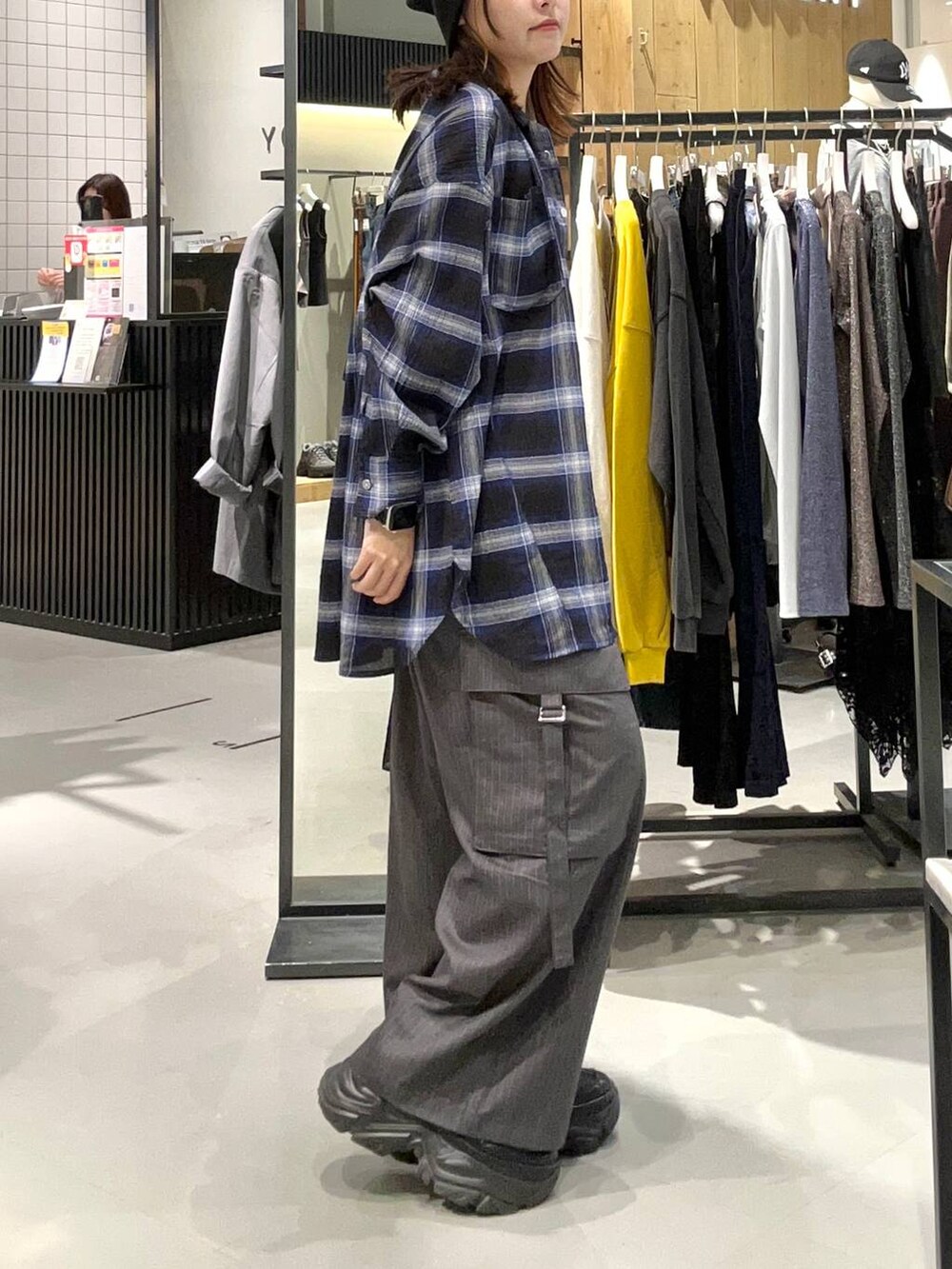 ブラック系のスニーカー、ブルー系のシャツ/ブラウス、グレー系のスラックスを着用したレディースの秋コーディネートの5枚目の写真