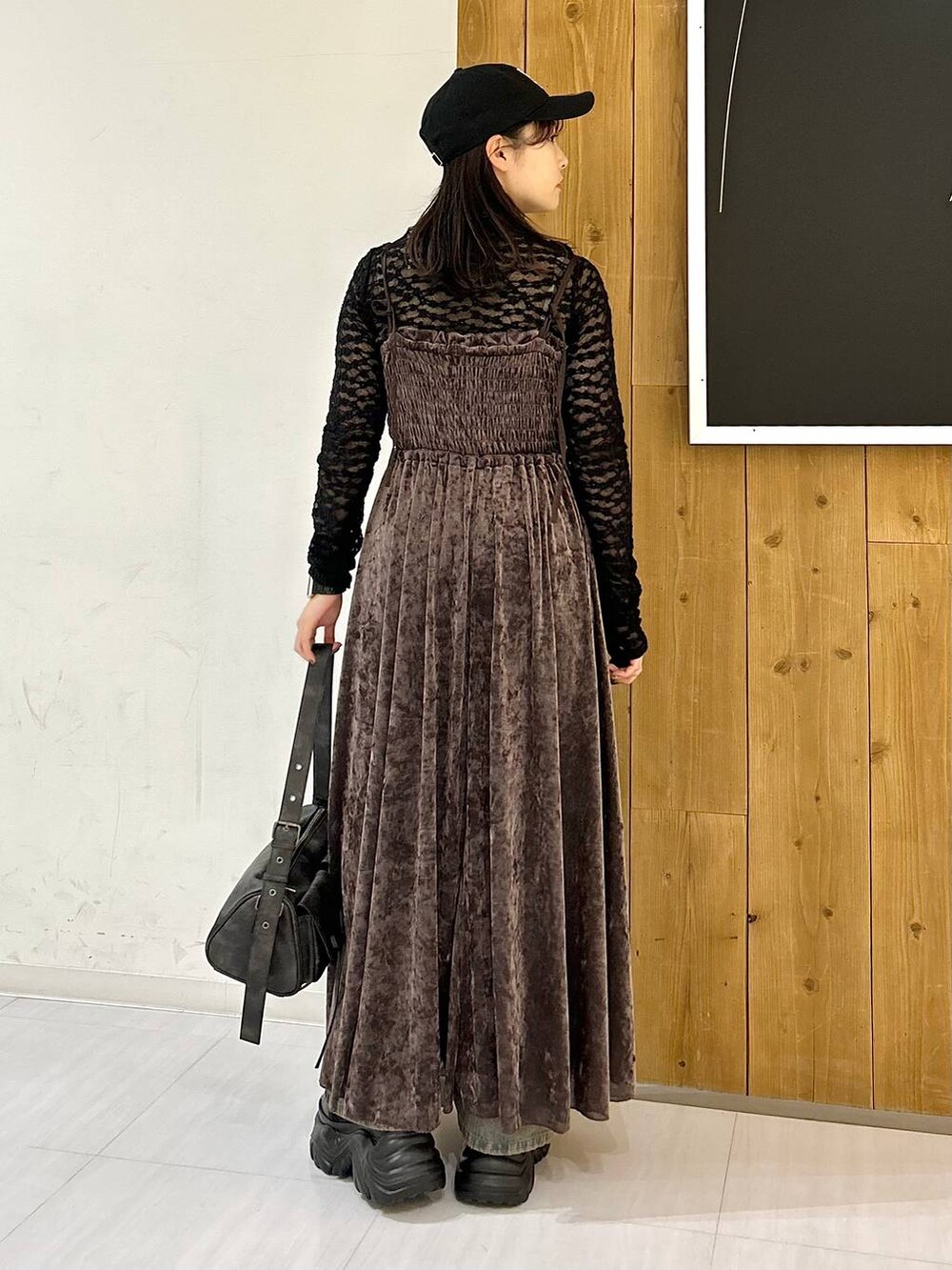 ブルー系のデニムパンツ、ブラック系のブーツ、ブラック系のキャミソールを着用したレディースの秋コーディネートの5枚目の写真