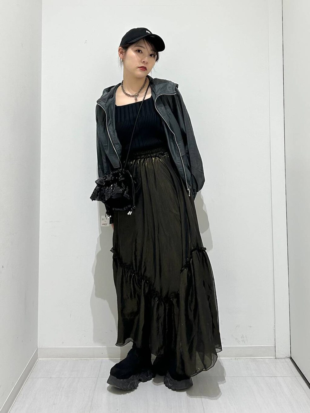 ブラック系のタンクトップ、ブラック系のスカート、グレー系のブルゾンを着用したレディースの春コーディネートの2枚目の写真