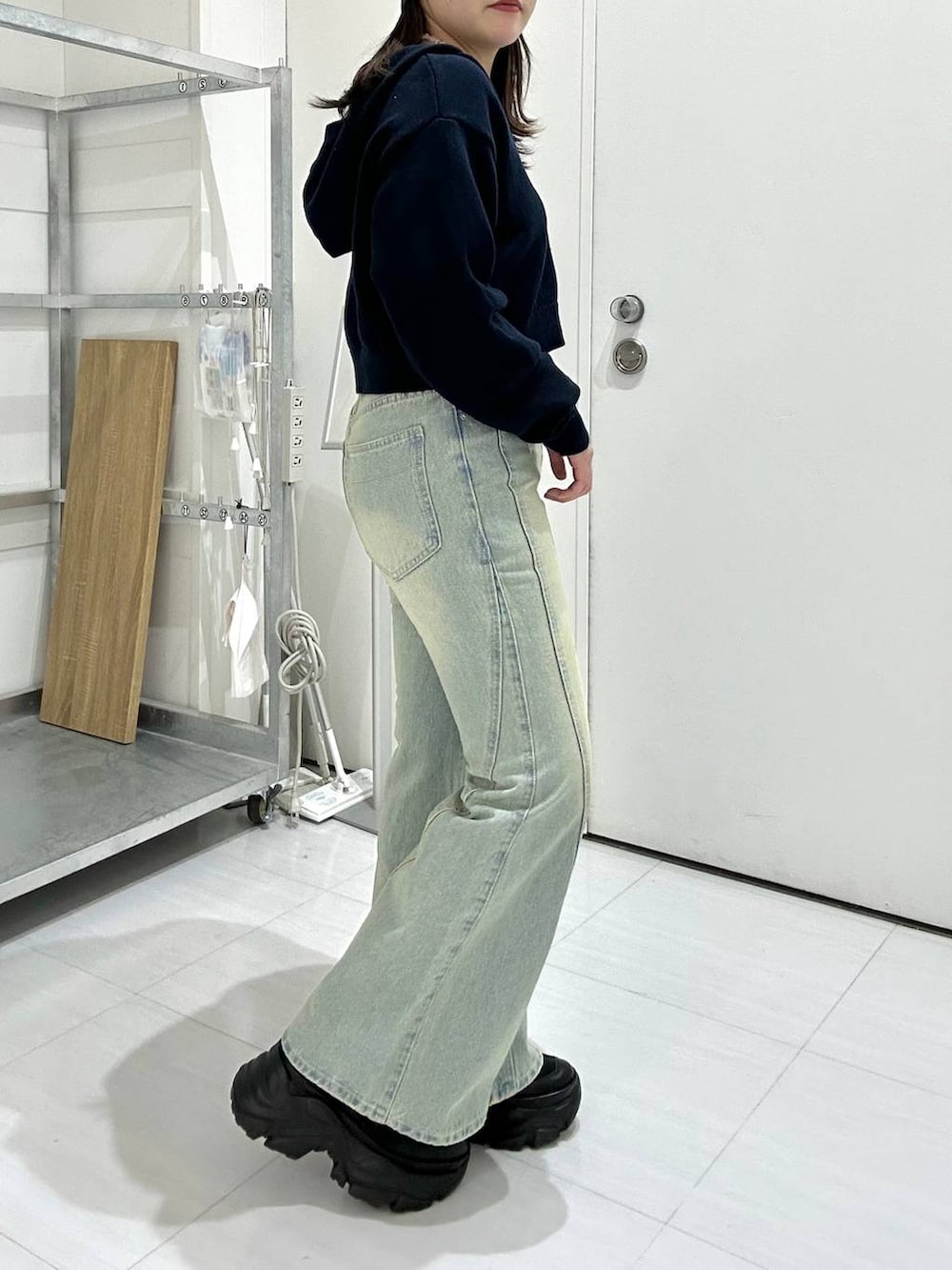 ブラック系のスニーカー、ブルー系のデニムパンツ、ブルー系のパーカーを着用したレディースの冬コーディネートの3枚目の写真