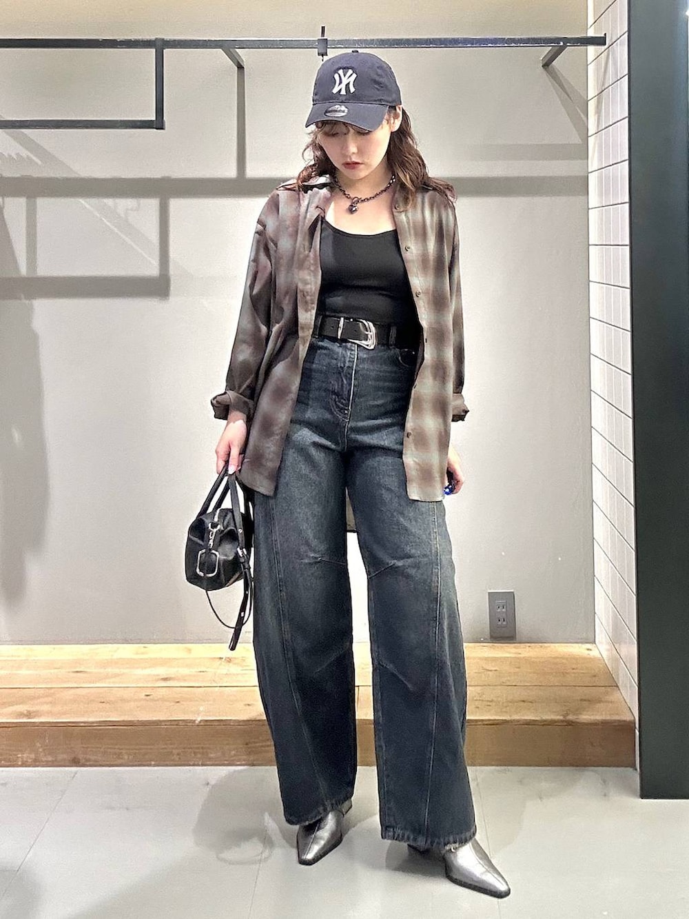 ブラック系のシャツ/ブラウス、ブルー系のデニムパンツ、ブラック系のショルダーバッグを着用したレディースの秋コーディネートの2枚目の写真