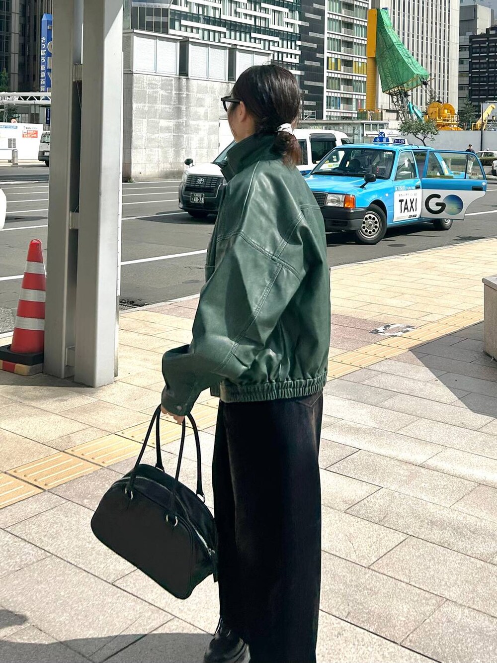 ブラック系のデニムパンツ、グリーン系のブルゾンを着用したレディースの秋コーディネートの4枚目の写真