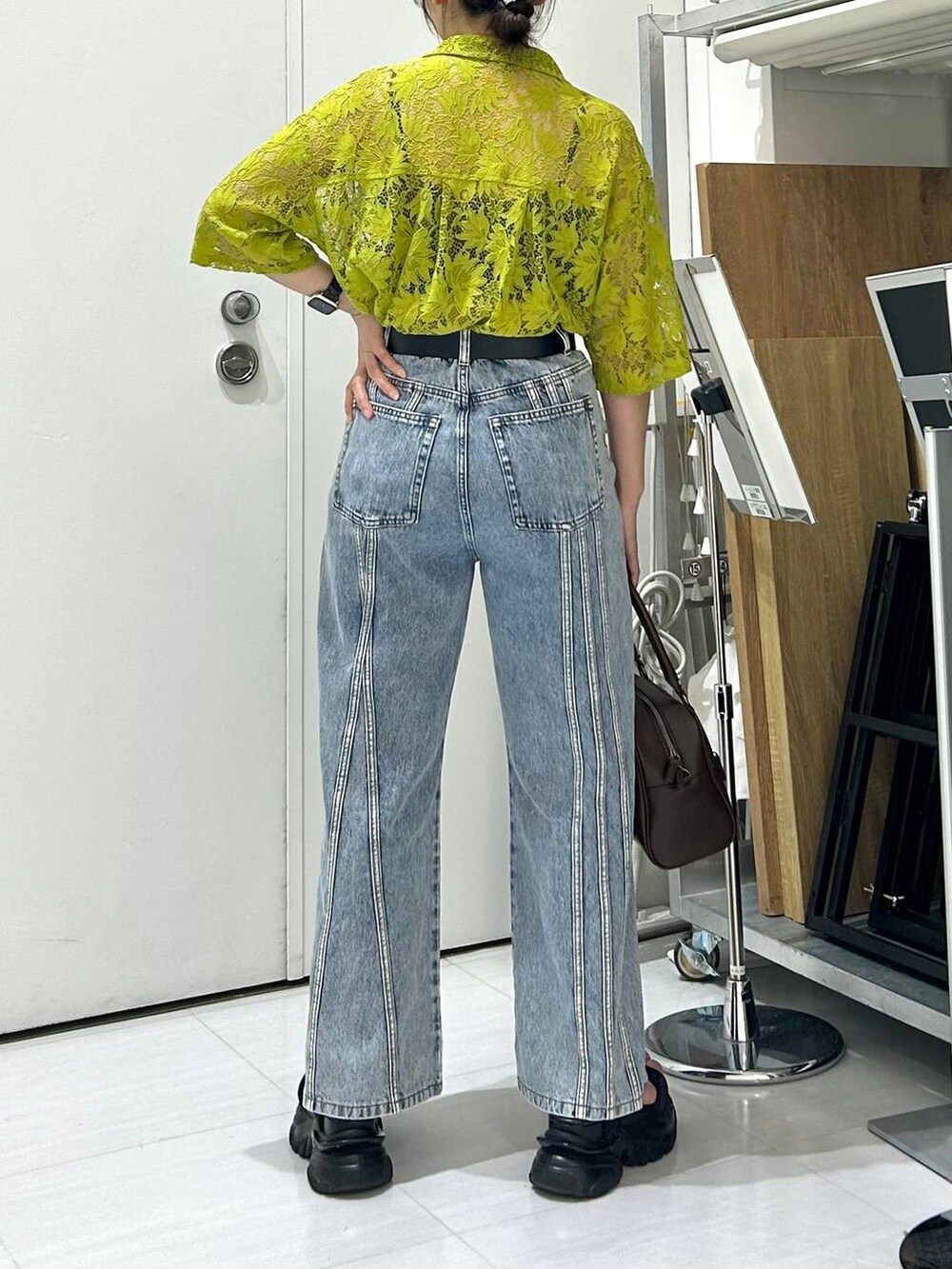 ブラック系のサンダル、ブラック系のキャミソール、ブルー系のデニムパンツを着用したレディースの夏コーディネートの7枚目の写真