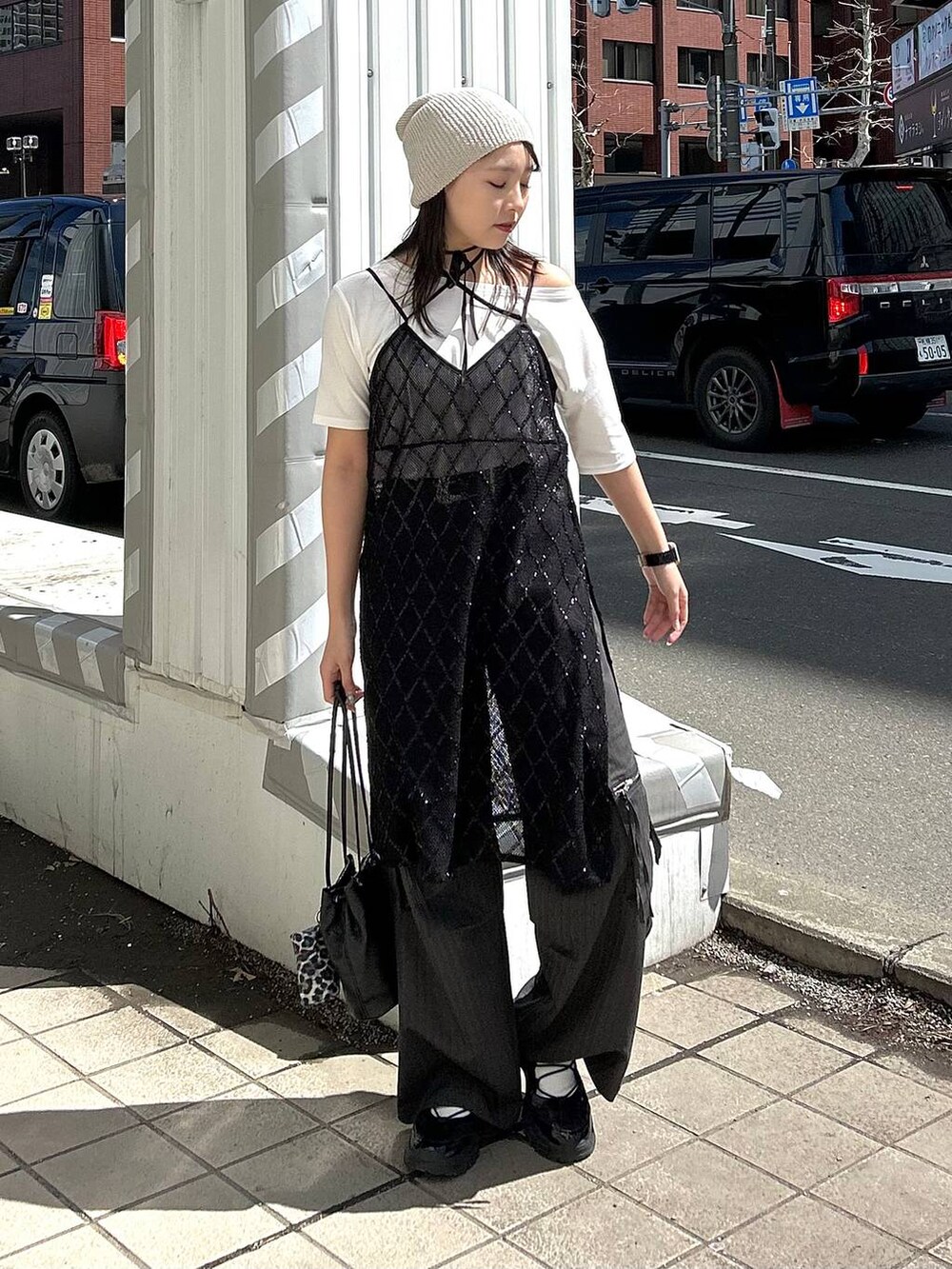 ブラック系のワンピース、ホワイト系のTシャツ/カットソー、ベージュ系のニットキャップ/ビーニーを着用したレディースの春コーディネートの5枚目の写真