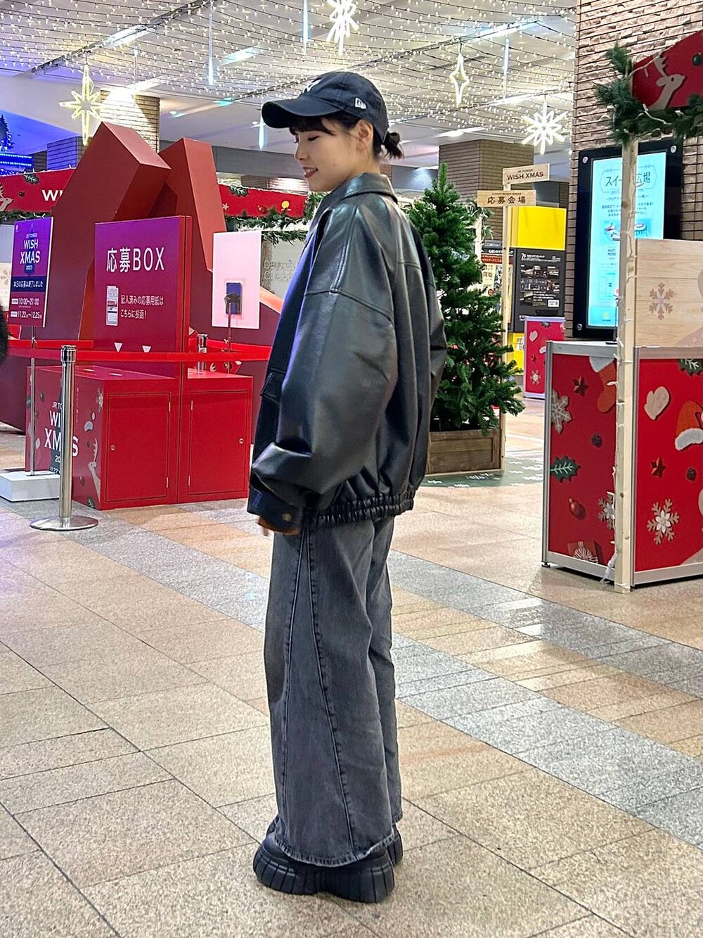 ブラック系のデニムパンツ、ブラック系のブルゾン、ブラック系のブーツを着用したレディースの秋コーディネートの4枚目の写真