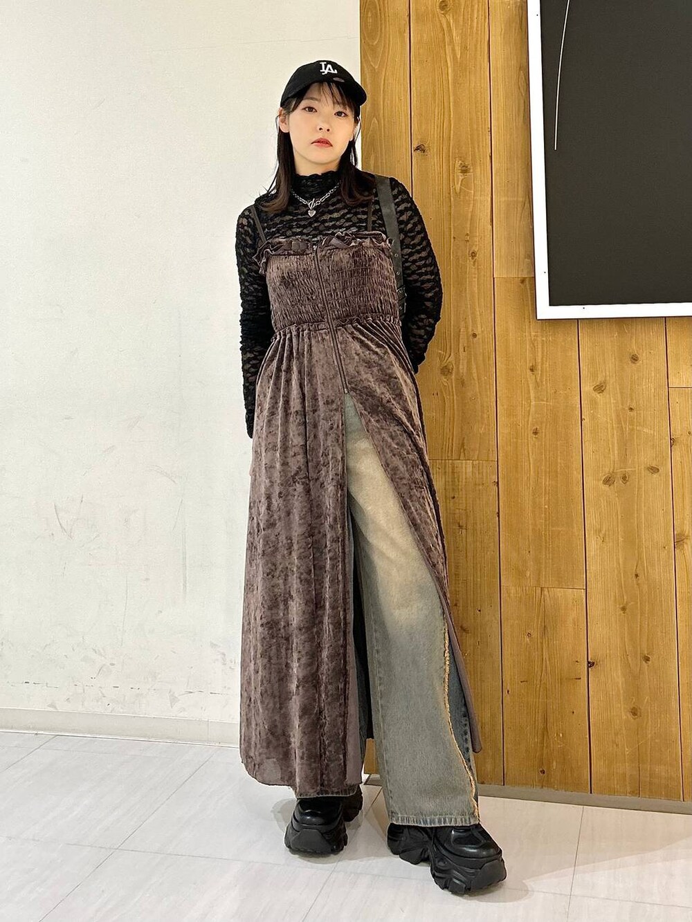 ブルー系のデニムパンツ、ブラック系のブーツ、ブラック系のキャミソールを着用したレディースの秋コーディネートの3枚目の写真