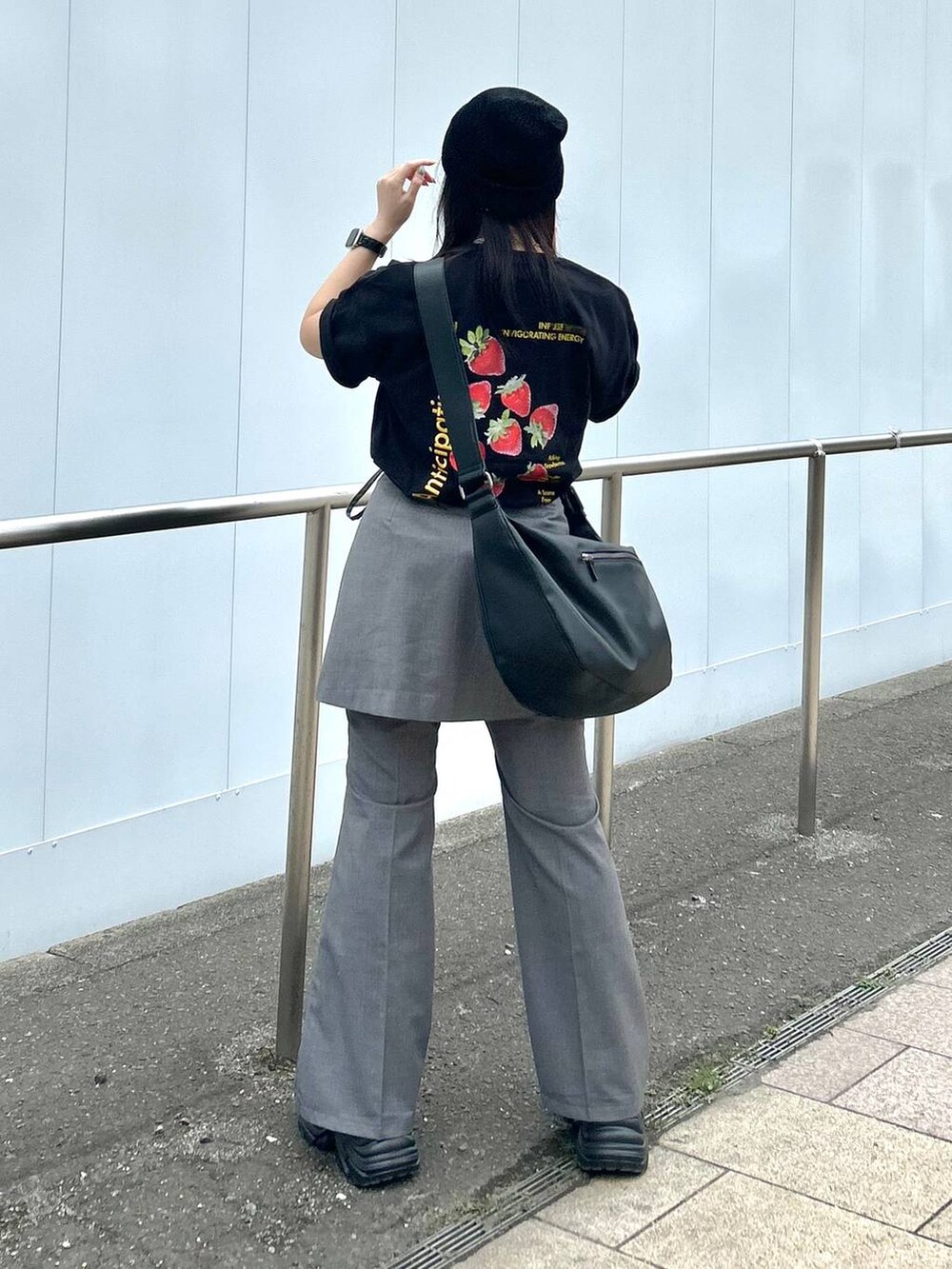 ブラック系のショルダーバッグ、グレー系のスカート、グレー系のスラックスを着用したレディースの春コーディネートの4枚目の写真