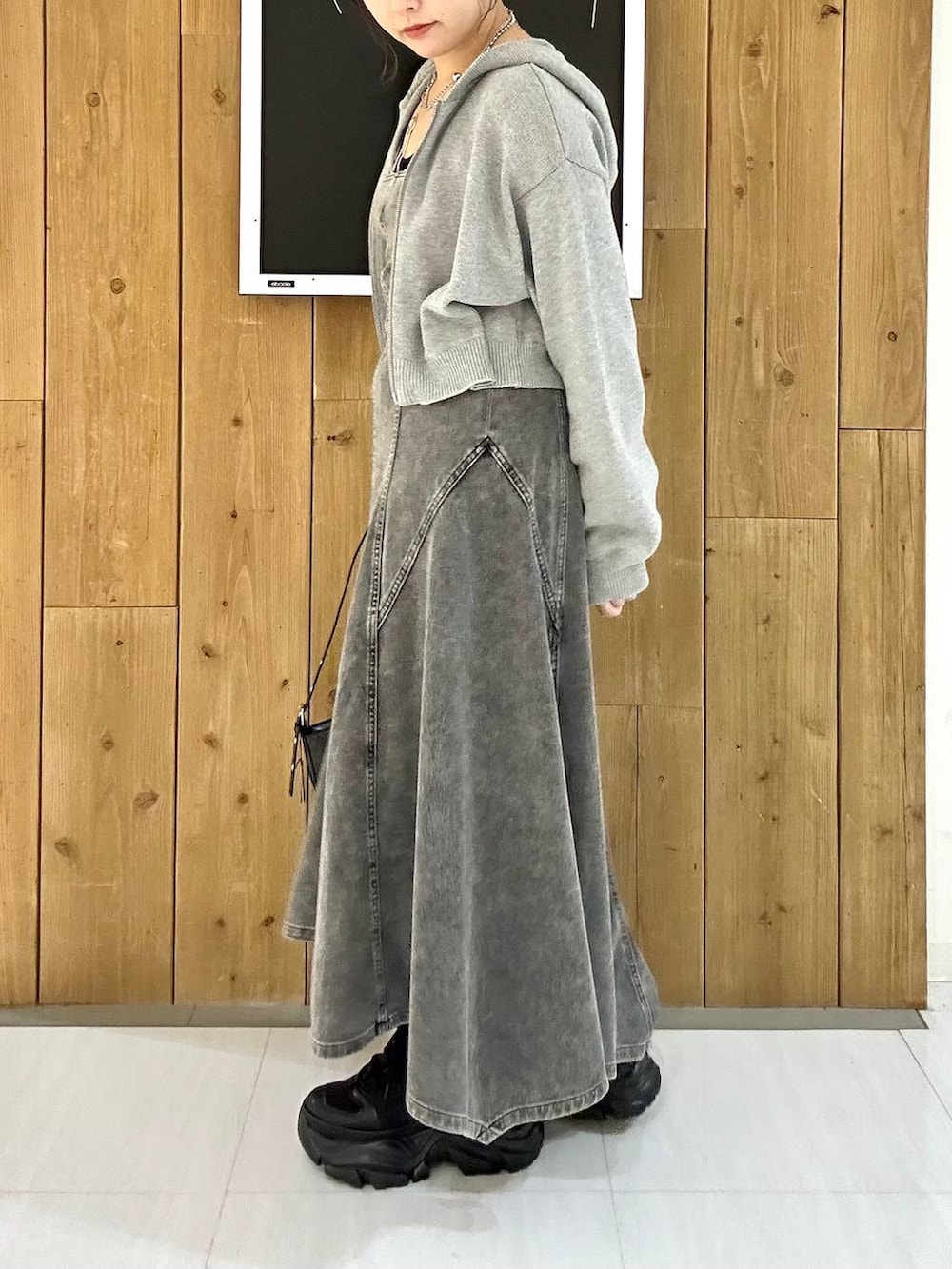 ブラック系のスニーカー、ブルー系のパーカー、ブラック系のハンドバッグを着用したレディースの冬コーディネートの5枚目の写真