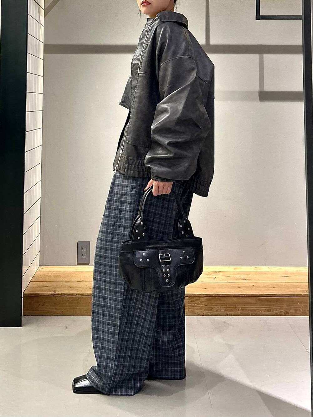 グレー系のブルゾン、ブラック系のブーツ、グレー系のスラックスを着用したレディースの秋コーディネートの6枚目の写真