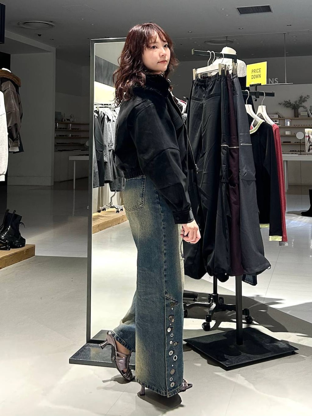ブラック系のブルゾン、ブルー系のデニムパンツ、ブラウン系のTシャツ/カットソーを着用したレディースの秋コーディネートの7枚目の写真